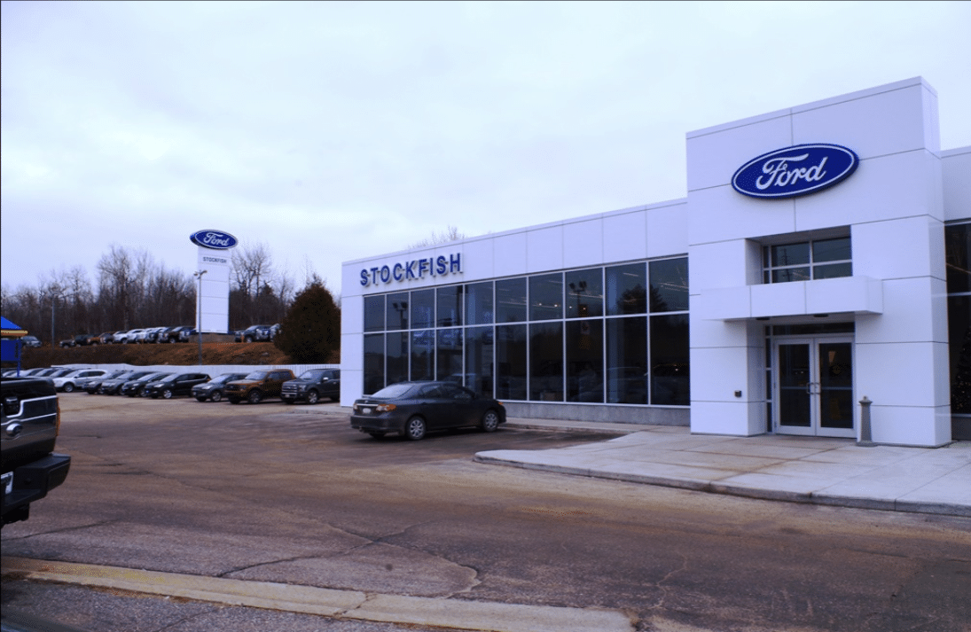 Stockfish Ford dealership exterior with modern architecture and a lineup of vehicles in the parking lot, showcasing the dealership's sign prominently.